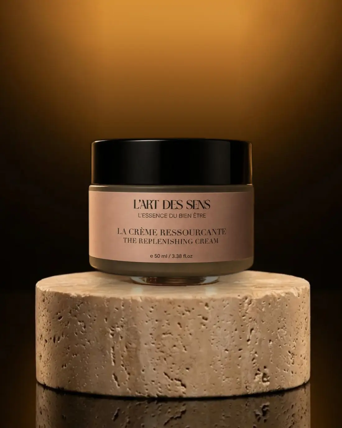 La Crème Ressourçante L’Art des Sens — pot 50 ml sur socle travertin, lumière dorée